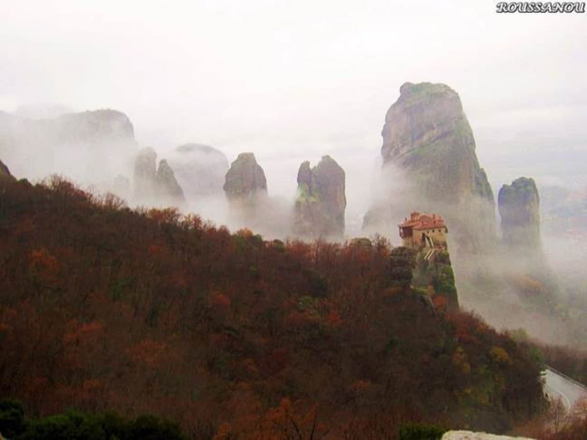 A monastery perched on a rock pillar at Meteora, half hidden in mist