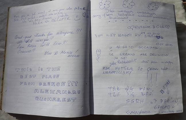 Pages of the hotel guest book, covered in handwritten messages from guests